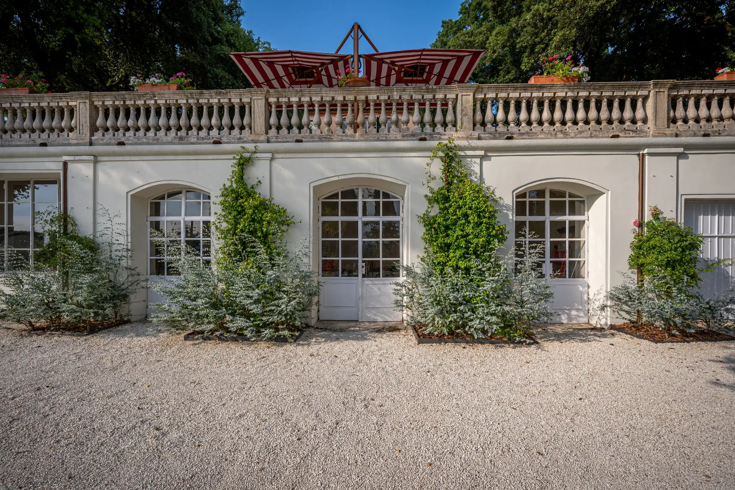 The historic limonaia with arched windows beneath the balustraded terrace