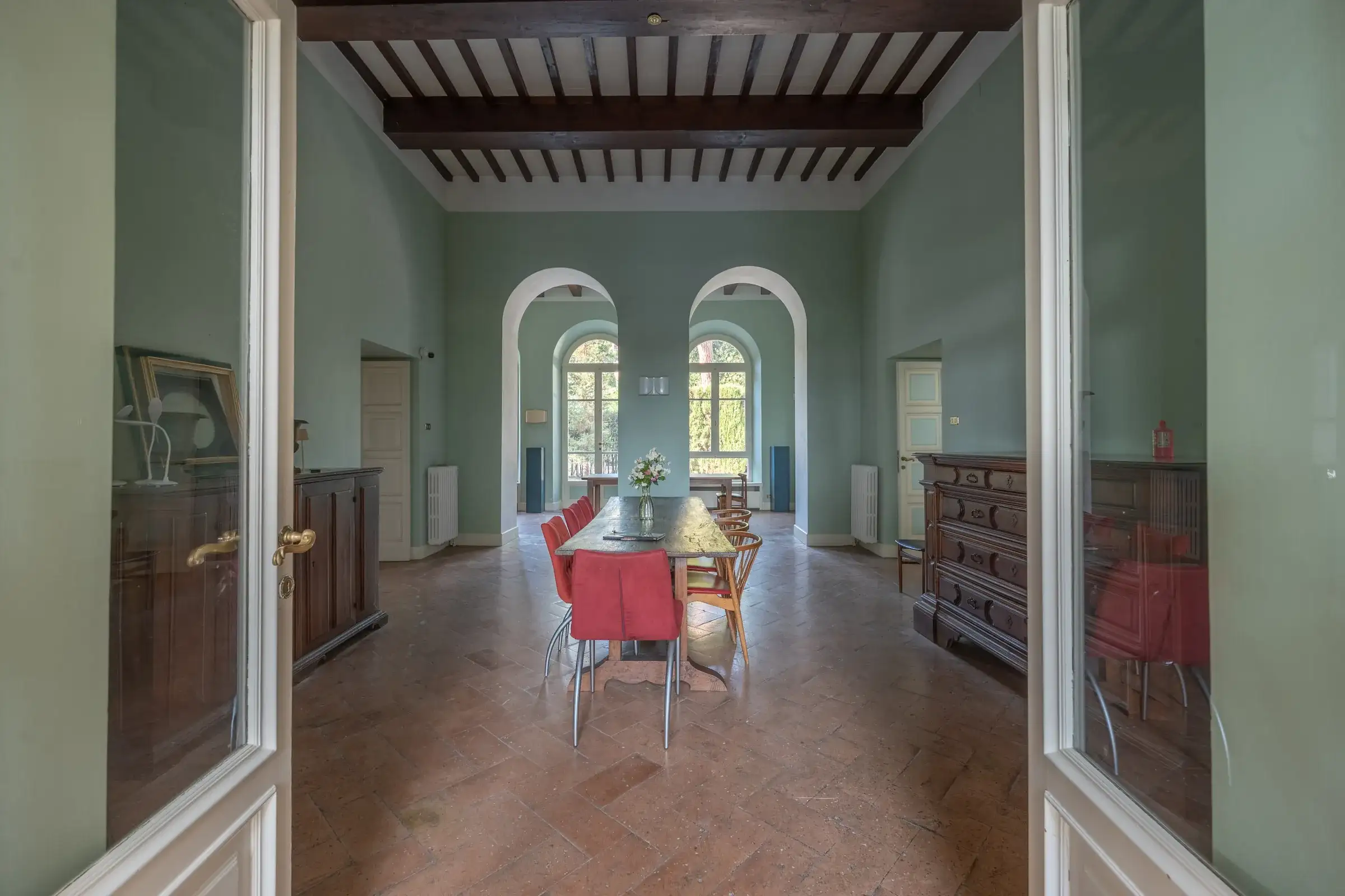 Dining room with beamed ceiling and arched windows